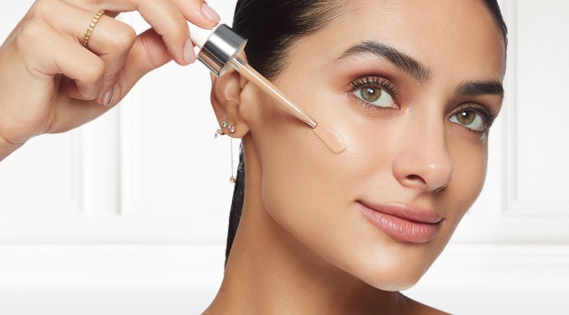 Modelo aplicándose el True Match Nude Sérum